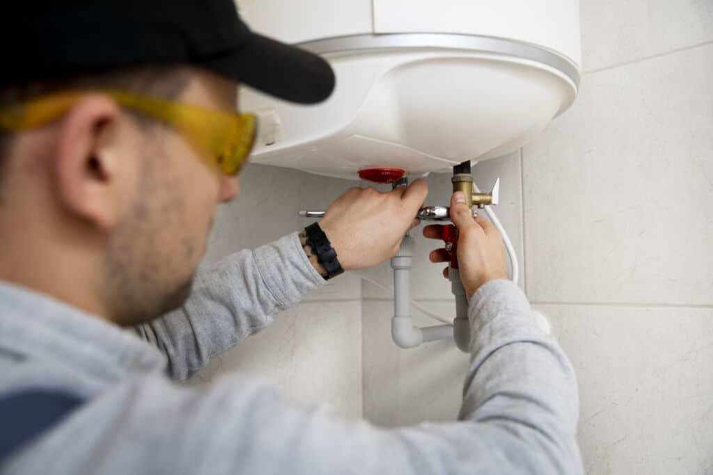 Plumber repairing water heater with tools, emphasizing professional plumbing services and maintenance.