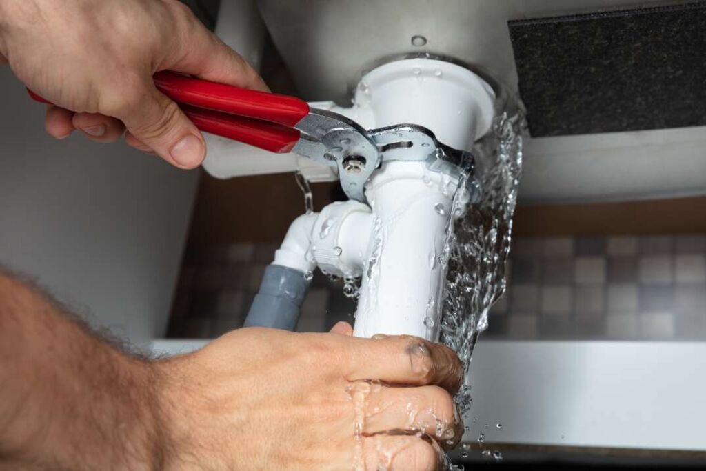 Service maintenance worker fixing a leaking pipe.