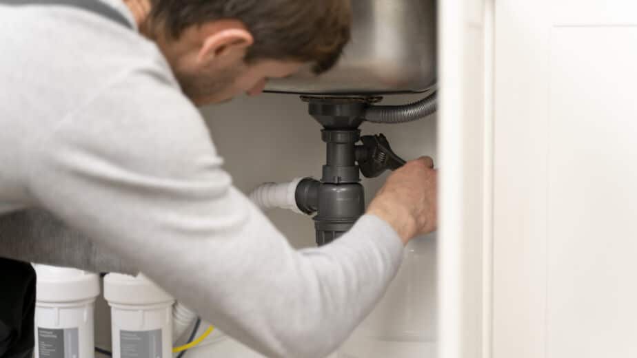 Service maintenance worker repairing pipes and drain