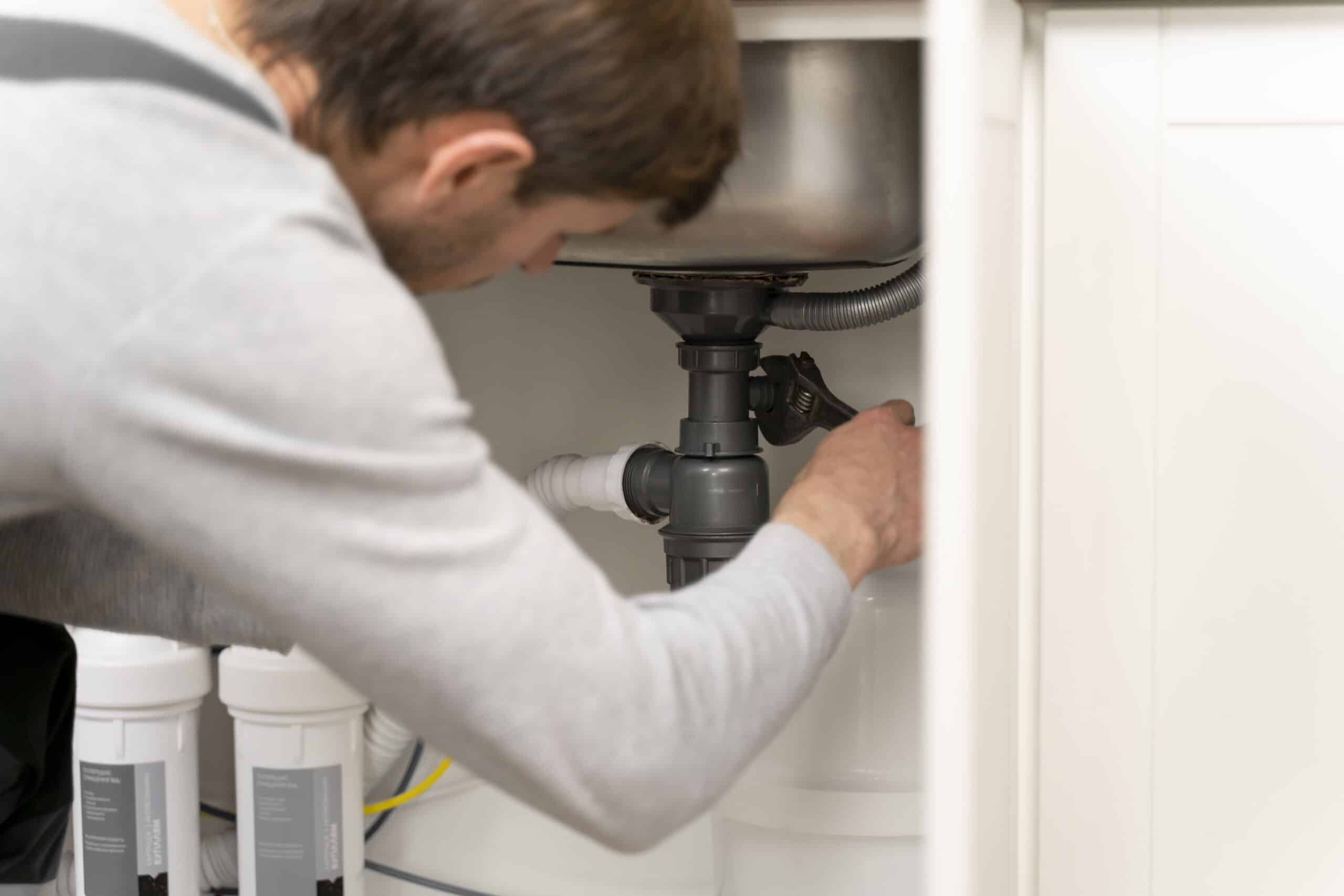 Service maintenance worker repairing pipes and drain