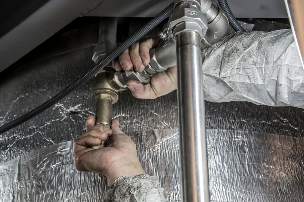 Professional plumber working to unclog a kitchen drain