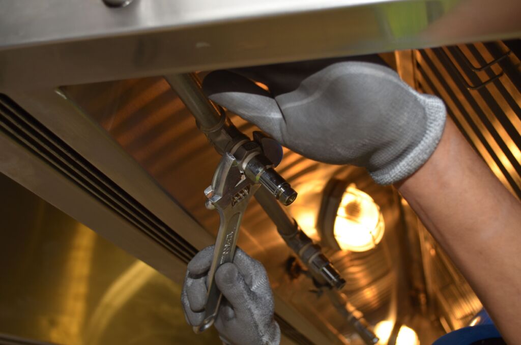 Professional plumber working to unclog a kitchen drain